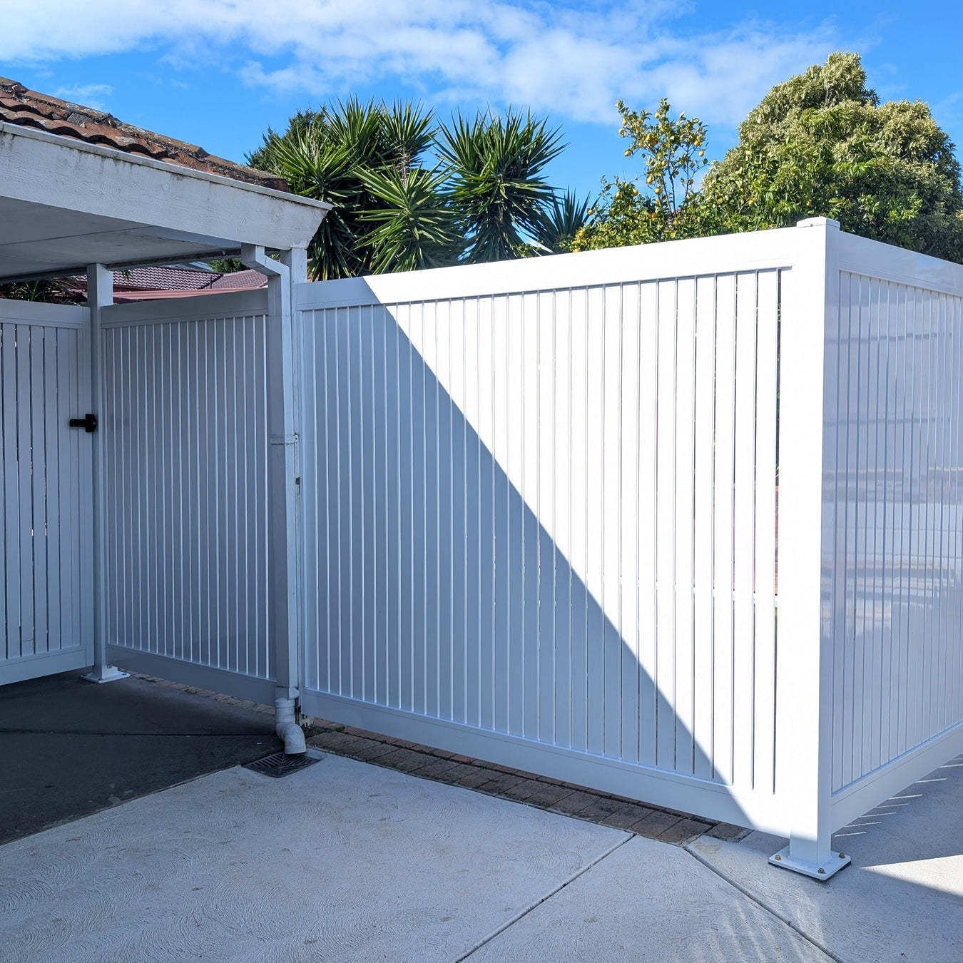 White hamptons aluminium fence with a gate in a residential setting